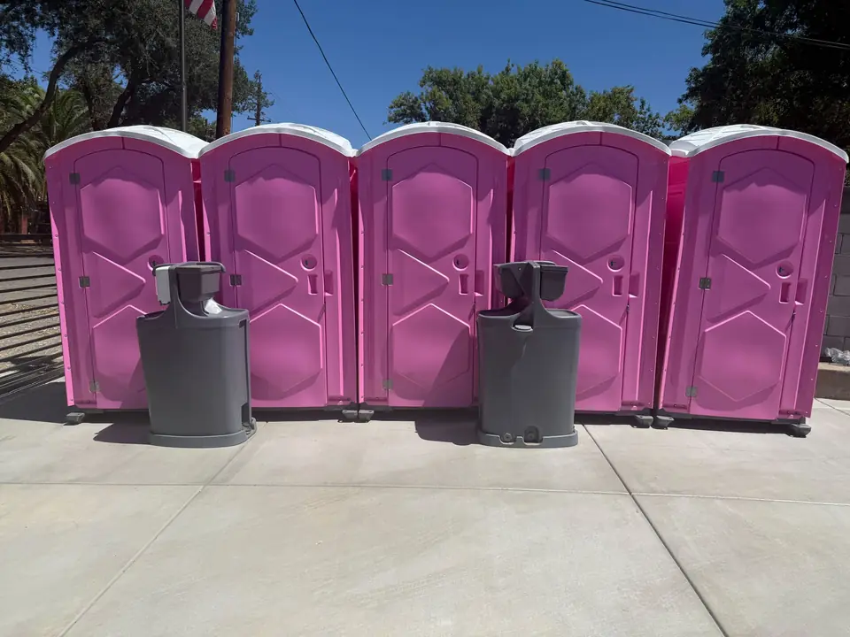 Pink event porta potties with two hand wash stations in front