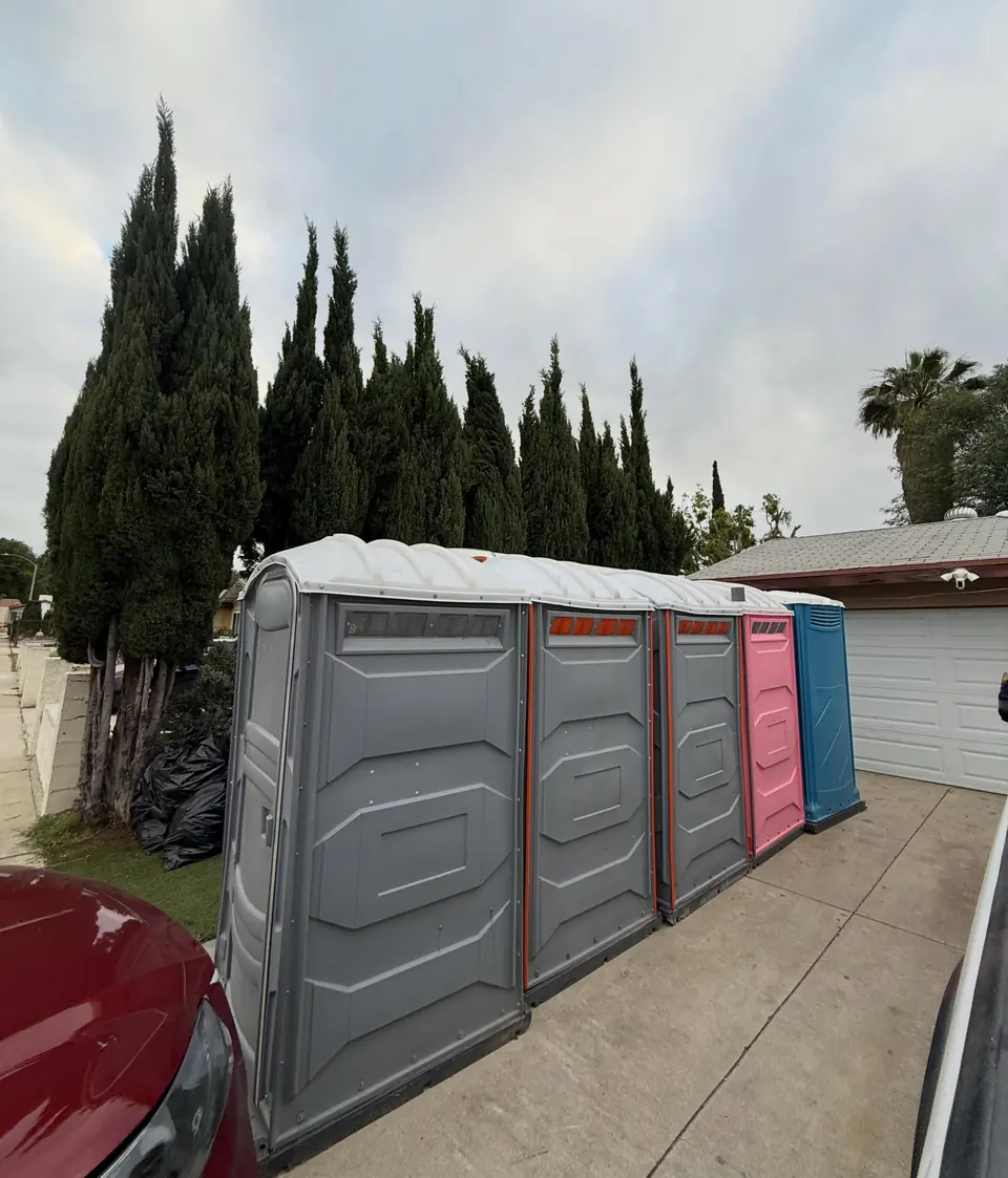 Row of porta potties along a driveway wall